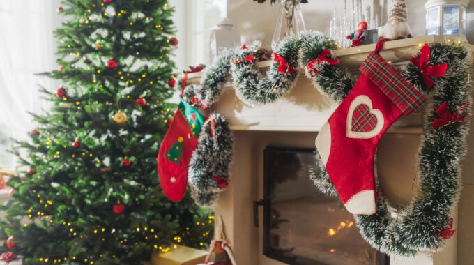 Empty Shot Depicting The Magic Of Holidays On A Peaceful Snowy Christmas Morning: Decorated Corner In Modern House With Christmas Tree, Fireplace And Gifts. Home Of A Family Celebrating With Joy